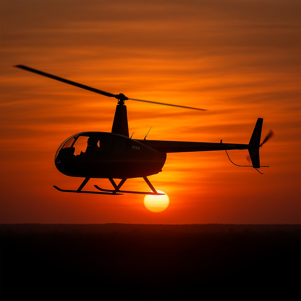 Helikoptervlucht bij zonsondergang